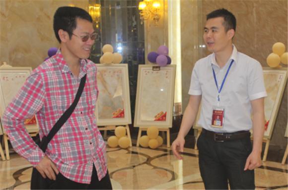 南宫娱乐网络营销主管王宏城（右一）向记者介绍微晶瓷片